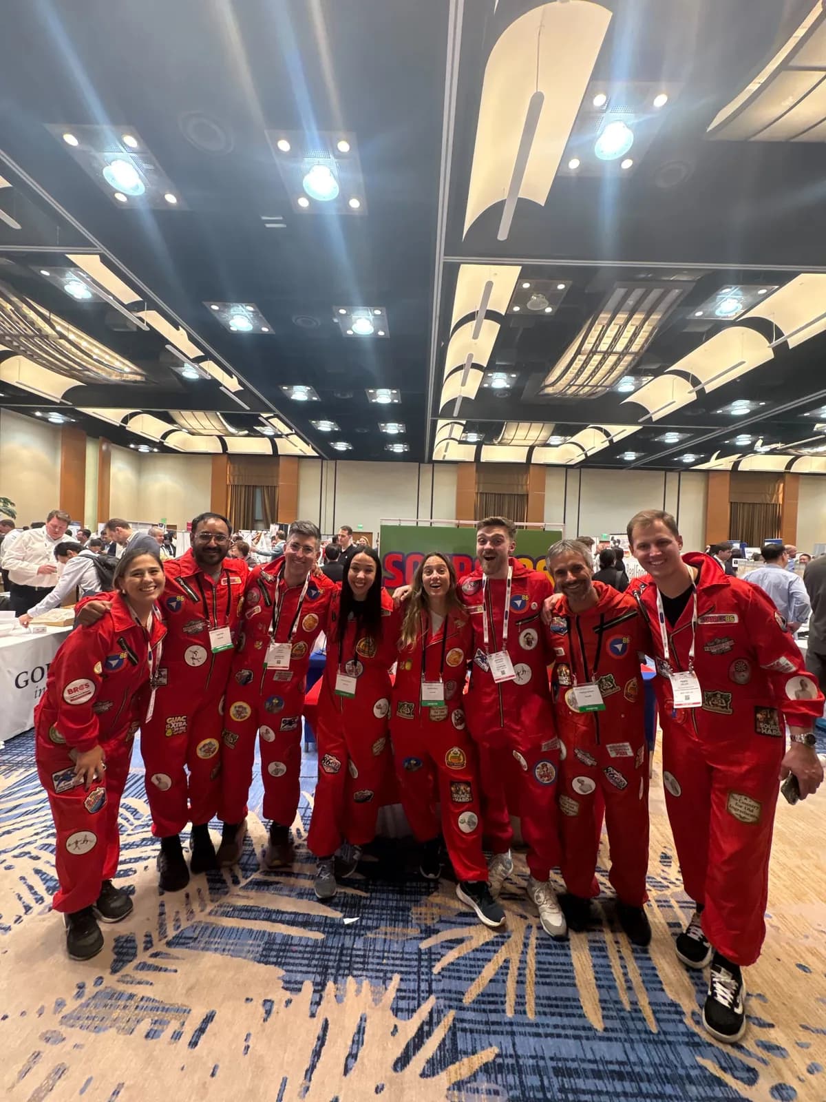The Pacific86 and Source86 team in red jumpsuits at a trade show booth.